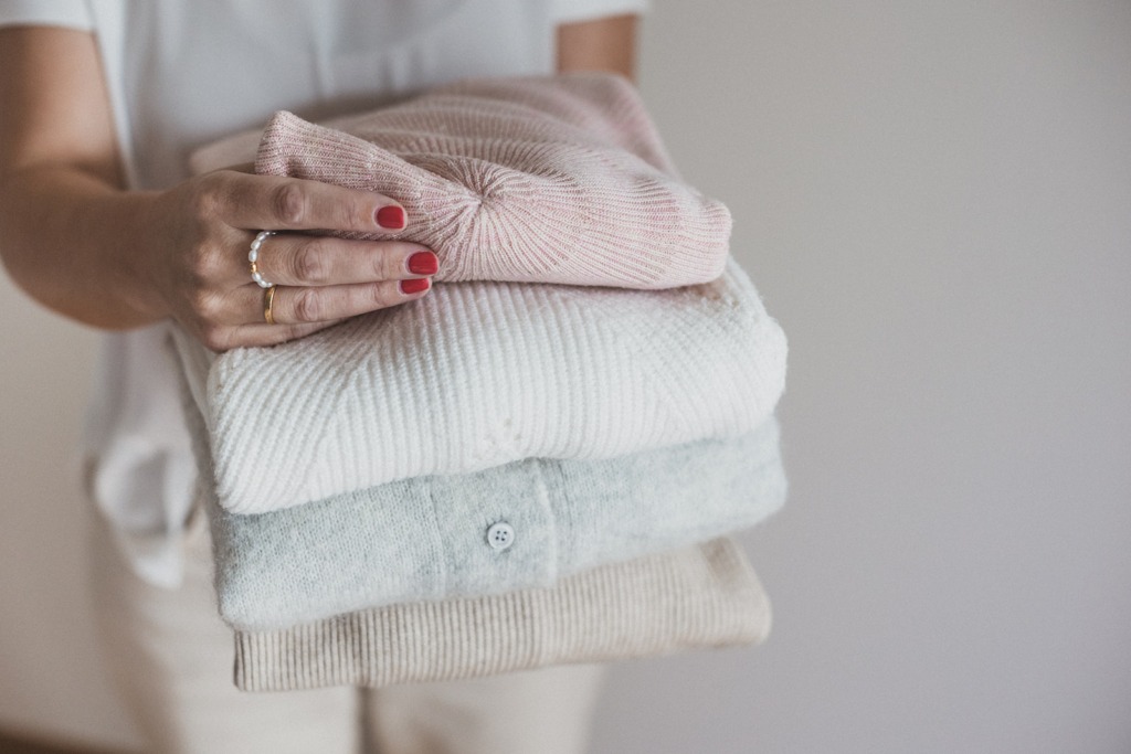 Dagmar Schäfer von Schrank trifft Stil (Capsule Wardrobe Beratung) mit gefalteten Pullovern in der Hand